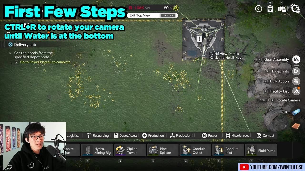 Top-down game view of a grassy base area with placement lines and a small structure marker, alongside an on-screen prompt about rotating the camera so water is at the bottom.